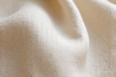 Dettaglio ravvicinato di un tessuto di lino grezzo, materiale per carta da parati ecologica.